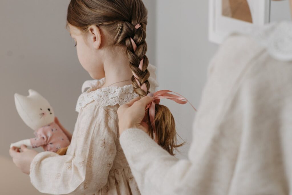 A serene moment as a mother braids her daughter's hair, creating a warm and intimate family setting.