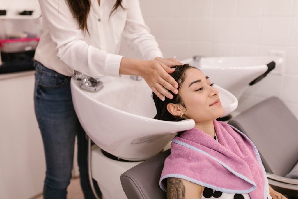 A woman enjoys a relaxing hair wash at a modern salon, symbolizing self-care and pampering.